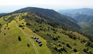overland vehicles lined up on top of a green mountain in romania taking a break