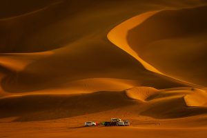 group of overland vehicles taking a break in the dunes of oman