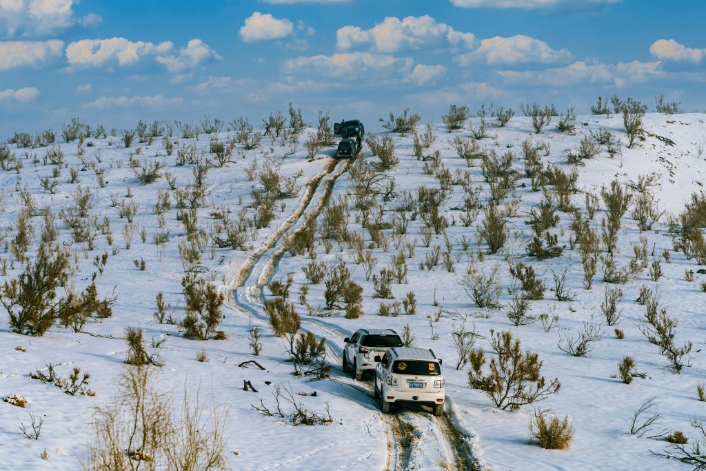 convoy of overland vehicles crossing a mountain in tajikistan